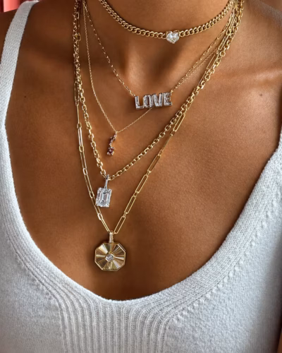 Layered gold necklaces with LOVE, emerald-cut diamond and medallion pendants